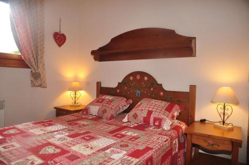 - une chambre avec un lit et deux lampes sur les tables dans l'établissement Résidence MGM 3* 199 Chemin du Verney du Fouilly les hauts de chavants, aux Houches