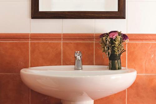 um lavatório de casa de banho com um vaso de flores em APARTAMENTO 1 CASA RURAL EL SAUCE. A 2,5 KM DE CUENCA CAPITAL em Nohales