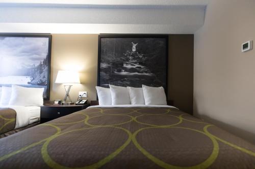 a hotel room with a bed with a yellow at Super 8 by Wyndham Canmore in Canmore