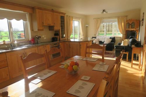 a kitchen with a table with a bowl of fruit on it at INGLEWOOD - Ballina - Crossmolina - County Mayo - Sleeps 8 - Sister property to Thistledown in Mayo