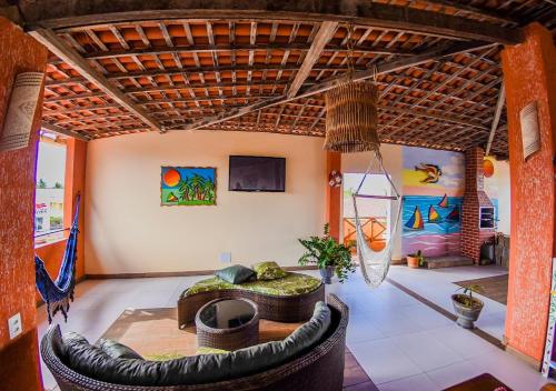 a living room with a large tire couch and a tv at Pousada Aconchego do Porto in Porto De Galinhas