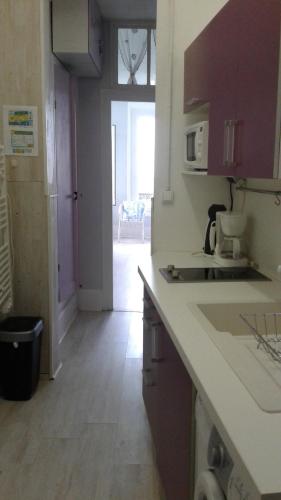 une cuisine avec un comptoir et une pièce avec une porte dans l'établissement 10 Quai François 1er, au Tréport