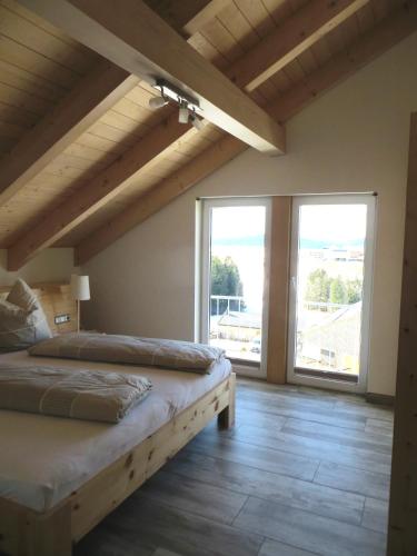 a bedroom with two beds and a large window at Ferienwohnung bei Maly in Sulzberg