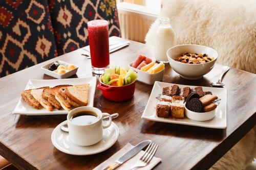 纳塔列斯港Hostal Boutique Factoria Patagonia的餐桌,带两盘食物和一杯咖啡的桌子