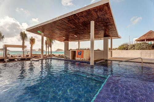 a swimming pool at a resort with a pavilion at Royalton CHIC Cancun, An Autograph Collection All-Inclusive Resort - Adults Only in Cancún