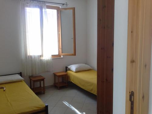 een kleine kamer met een bed en een raam bij Villa Solinas in Sorso