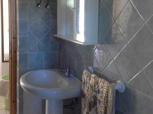een badkamer met een wastafel en een spiegel bij Villa Solinas in Sorso
