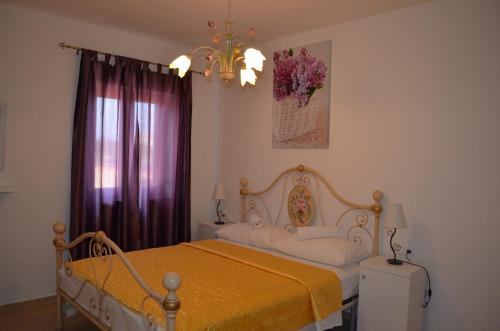 a bedroom with a bed with a yellow blanket at Villa Claudia in Fažana