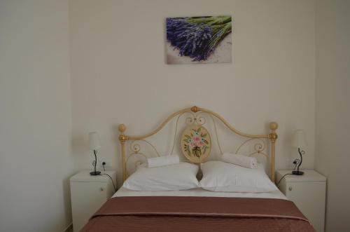 a bed with a wooden headboard and two night stands at Villa Claudia in Fažana