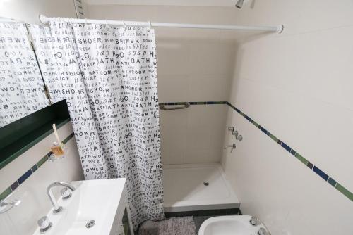 een badkamer met een douchegordijn, een wastafel en een toilet. bij Maipuhc in Buenos Aires