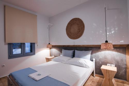 1 dormitorio con 1 cama blanca grande y 2 lámparas en Kallisti Studios & Apartments en Skyros