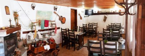 a restaurant with chairs and a table with a guitar at Yakovtsi Inn in Yakovtsi