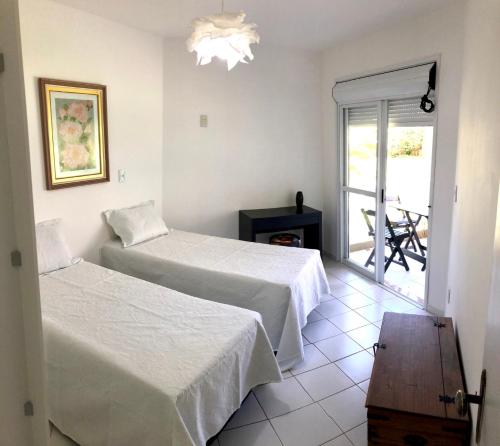 a hotel room with two beds and a balcony at Lindo apto beira da Lagoa in Florianópolis