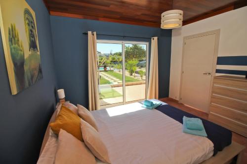 a bedroom with a large bed and a large window at Quinta Gomes in Lagos