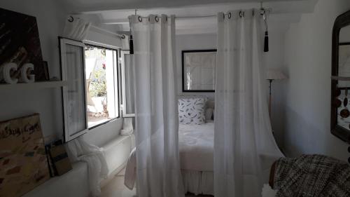a white bedroom with a bed and a window at Casa Blanca in Altea