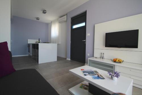 a living room with a black door and a tv at Villa Lavanda Deluxe in Rogoznica