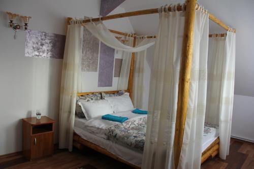 Panaite’s Home في نيهويو: غرفة نوم مع سرير مظلة مع ستائر بيضاء