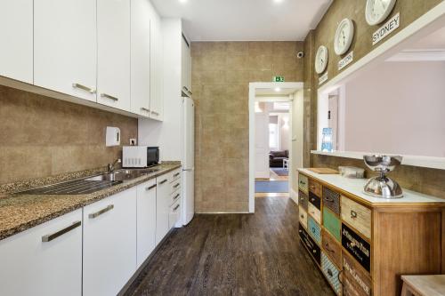 a kitchen with white cabinets and wooden floors at Fishtail Sea House in Matosinhos