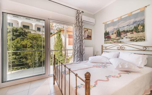 um quarto com uma cama e uma grande janela em Reseda House em Zakynthos