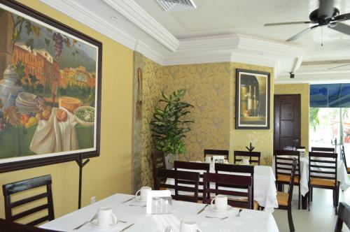 a restaurant with tables and chairs and a painting on the wall at hotel villa magna poza rica in Poza Rica de Hidalgo