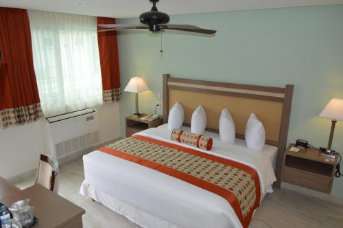 um quarto com uma cama grande e uma ventoinha de tecto em hotel villa magna poza rica em Poza Rica de Hidalgo
