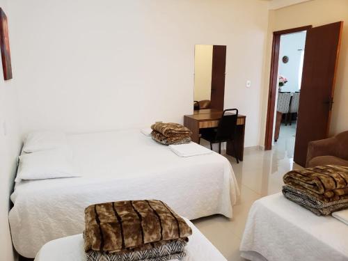 a hotel room with two beds and a table with towels at Yolanda Family House in Foz do Iguaçu