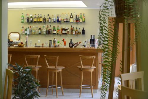 a bar with bar stools and bottles on the wall at Hotel Do Campo in Ribeira Brava