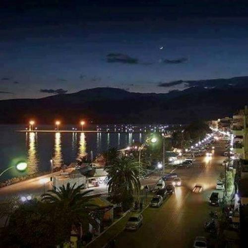 a city at night with cars parked next to the water at Luxury seafront house nearby Delphi in Kírra