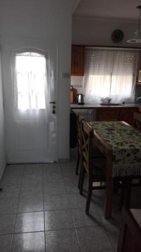 cocina con mesa, ventana y puerta en Roberta en Bahía Blanca