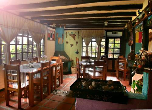 Chasqui的住宿－Rondador Cotopaxi，一间带桌子和壁炉的用餐室