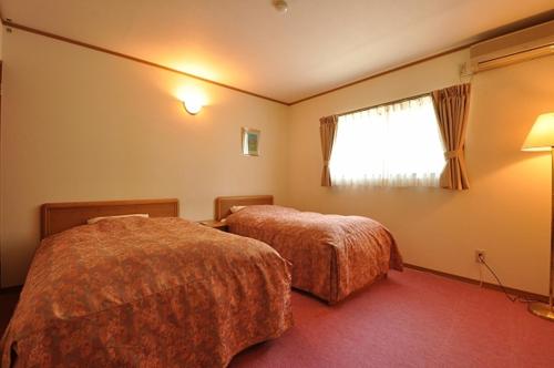 a hotel room with two beds and a window at Ryuudo in Minakami