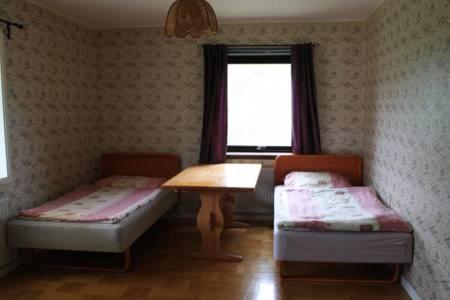 um quarto com duas camas e uma mesa e uma janela em Nice house in a quite place em Kalix