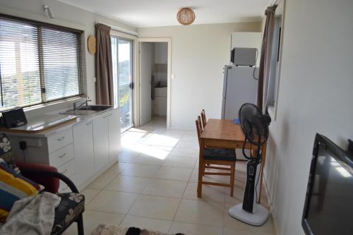 a kitchen with a table and a refrigerator at Private Beach Cottage At Ecostays in Greenough