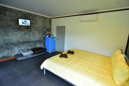 a bedroom with a bed and a tv on a wall at Music Khao Kho in Khao Kho