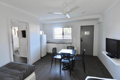 a living room with a table and chairs and a kitchen at Ballina Homestead Motel in Ballina