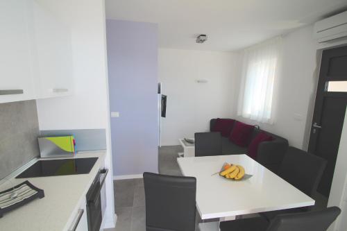 a small kitchen with a white table and chairs at Villa Lavanda Deluxe in Rogoznica