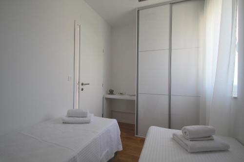 a white room with two beds and a mirror at Villa Lavanda Deluxe in Rogoznica