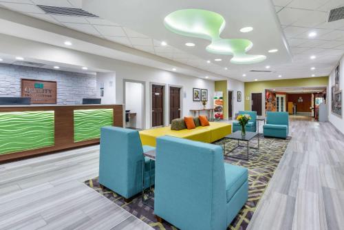 vestíbulo con sofá amarillo y sillas azules en Quality Inn and Suites Riverfront en Palatka