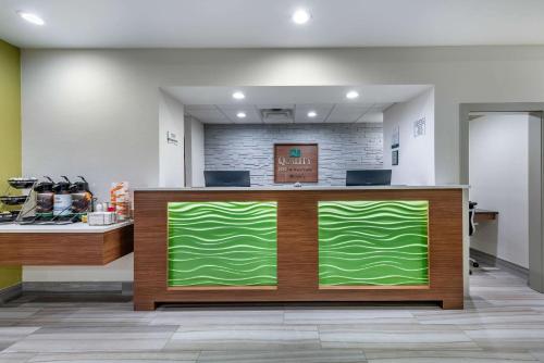 パラトカにあるQuality Inn and Suites Palatka Riverfrontのロビーの緑のカウンター付き店舗