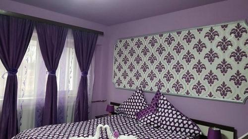 a bedroom with a bed with black and white pillows at Garsoniera Cristina in Baile Felix