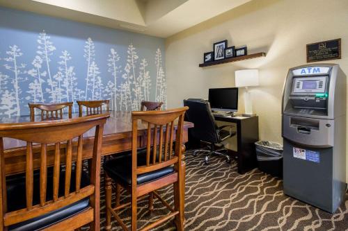 a hotel room with a bar and a desk with chairs at Sleep Inn & Suites in Rapid City