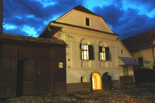 an old house with its lights on at night at Pensiunea ARANYOS in Rimetea