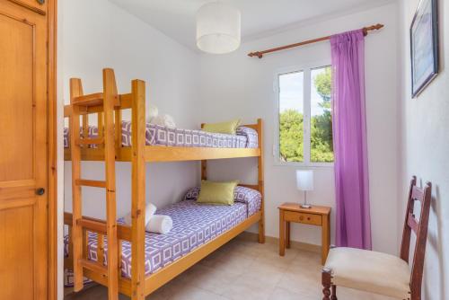 una camera con due letti a castello e una finestra di Apartamentos Ses Fonts a Son Parc