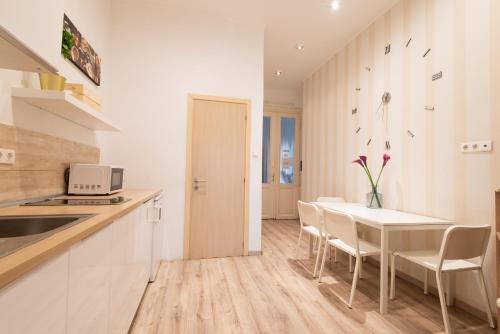 cocina y comedor con mesa y sillas en Standard Apartment by Hi5 - West End Center, en Budapest