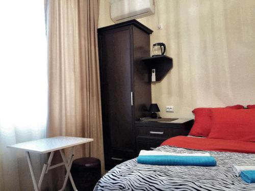 a bedroom with a bed with a desk and a sink at Guesthouse Next to beach in Batumi