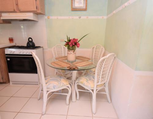 a kitchen with a table and two chairs and a stove at The Sugar Apple Lodging in Harbour Island