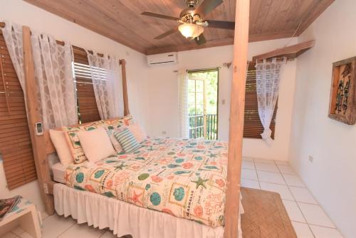 a bedroom with a bed and a ceiling fan at The Sugar Apple Lodging in Harbour Island