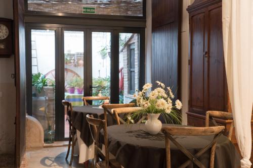 a dining room with a table with a vase of flowers on it at Casa Arizo, Hotel Boutique in Oropesa del Mar