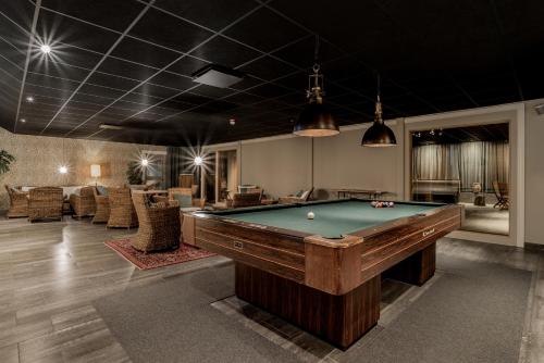 a billiard room with a pool table and chairs at Blommenhof Hotel in Nyköping
