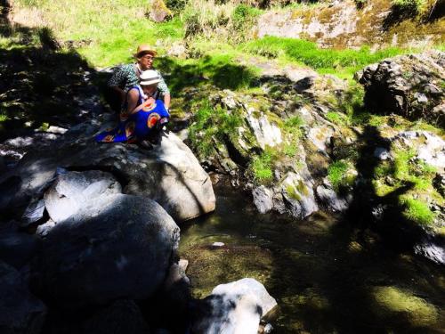 two people sitting on rocks next to a river at Guesthouse Fuki Juku in Fuki